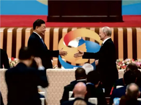  ?? LOUISE DELMOTTE/ASSOCIATED PRESS ?? Chinese President Xi Jinping and Russian President Vladimir Putin shook hands during a conference in Beijing.