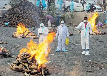  ?? Efe ?? •
En Bhopal (India) la gente observa las piras funerarias para víctimas del coronaviru­s.