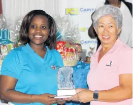  ?? PHOTO BY LENNOX ALDRED ?? President of the Kiwanis Club of New Kingston, Jhenell Allen (left), presents Susan White with her first-place trophy for winning the lady’s division of the Kiwanis Club of New Kingston Charity Golf Tournament, at Caymanas Golf and Country Club yesterday.