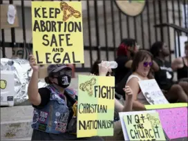  ?? Associated Press ?? Protesters sit on the steps of the Georgia state Capitol on June 26 while protesting the overturnin­g of Roe v. Wade. The Georgia Supreme Court on Wednesday reinstated the state’s ban on abortion after six weeks of pregnancy.