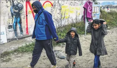  ?? Picture: SWNS.com ?? Migrants leave the Calais ‘Jungle’ as demolition work begins