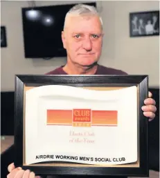  ?? ?? Winning feeling Club member Ian Wilson with one of the many awards handed out to the well-known local darts venue