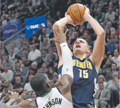  ?? Gene Sweeney Jr., Getty Images ?? Nuggets center Nikola Jokic shoots over Utah Jazz guard Joe Johnson during the second half Wednesday night in Denver’s 106-96 loss at Vivint Smart Home Arena in Salt Lake City. Jokic scored only seven points in 36 minutes.