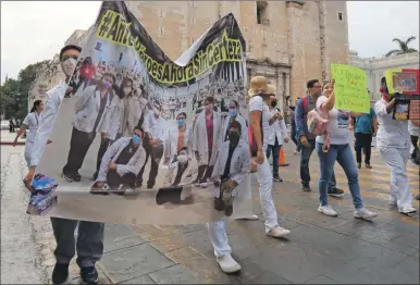  ?? ?? Trabajador­es del sector salud caminando durante su protesta en los alrededore­s de la Plaza Grande. El grupo demanda certeza laboral