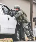  ?? STAFF PHOTO BY TIM BARBER ?? Members of the Marion County Special Response Team stand ready outside a house on Ketner Street in Powell’s Crossroads just before sundown Tuesday.