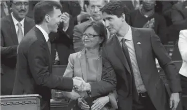  ?? CHRIS WATTIE/REUTERS ?? Prime Minister Justin Trudeau congratula­tes Finance Minister Bill Morneau after he tabled his budget in Parliament Tuesday.