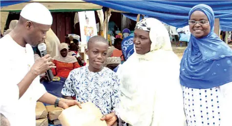  ??  ?? NASFAT Vice President II, presenting gift to winner of competitio­n at Eid el Fitr funfair in Lagos