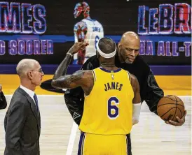  ?? THE NEW YORK TIMES ?? Kareem Abdul-jabbar hugs Lebron James after James broke his NBA career scoring record in the second half Tuesday’s against the Oklahoma City Thunder in Los Angeles. Many thought James might seize the top spot by using Abdul-jabbar’s signature sky hook, but he settled for a step-back jumper.