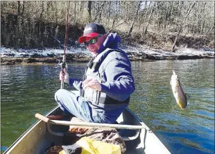  ?? Staff photograph by Flip Putthoff ?? With snow still on the ground, Keith Brashers catches a rainbow trout during a float trip on the White River below Beaver Dam. Launching at the dam and floating to Houseman Access makes a fine 7-mile canoe trip.