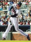  ??  ?? Atlanta’s Freddie Freeman connects for a sacrifice fly to center field during the first inning Saturday. Ronald Acuna Jr. scored on the play.