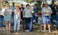  ?? NWA Democrat-Gazette/CHARLIE KAIJO ?? Attendees stand for the pledge of allegiance Saturday during a fundraisin­g picnic at the city park in Little Flock. The picnic is a fundraiser for the Democratic Party of Benton County, an event with a history of at least 50 years.