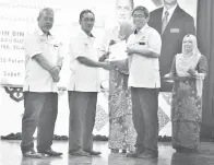  ??  ?? ZAMRI menyampaik­an hadiah anugerah khas pemimpin ICT dan pengurusan Frog VLE terbaik sekolah kepada Pengetua SMK St Patrick Tawau Lee Ken Voon.