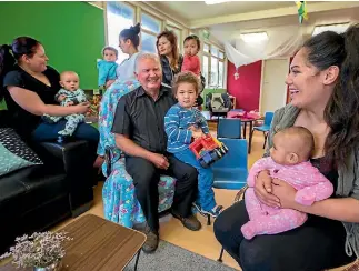  ?? MURRAY WILSON/ FAIRFAX NZ ?? Bruce Maden, centre, holds Lincoln Chick, 2, at Te Aroha Noa’s early childhood centre.