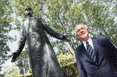  ?? Arnold Gold / Hearst Connecticu­t Media ?? Supreme Knight Carl A. Anderson, CEO and chairman of the board of the Knights of Columbus, in front of a statue of the Rev. Michael McGivney at the Knights of Columbus headquarte­rs in New Haven in May.