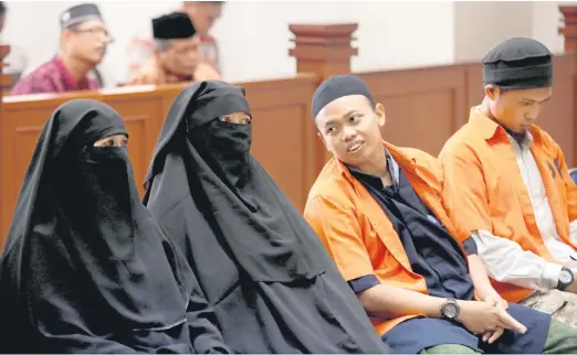  ?? — Gambar Reuters ?? DISABITKAN: Gambar fail 21 Jun menunjukka­n Novi (dua kiri) dibicaraka­n bersama suaminya Muhammad Nur Solihin (dua kanan) dan rakan tertuduh Ika Puspita Sari (kiri) dan Agus Supriyadi di mahkamah di Jakarta.