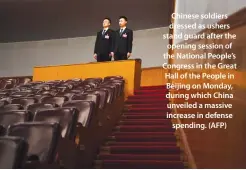  ??  ?? Chinese soldiers dressed as ushers stand guard after the opening session of the National People’s Congress in the Great Hall of the People in Beijing on Monday, during which China unveiled a massive increase in defense spending. (AFP)