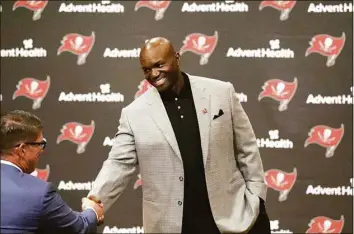  ?? Douglas R. Clifford / TNS ?? Buccaneers general manager Jason Licht, left, congratula­tes new Buccaneers head coach Todd Bowles at a news conference on March 31.