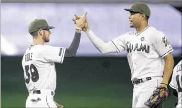  ?? LYNNE SLADKY / ASSOCIATED PRESS ?? Marlins rookie shortstop J.T. Riddle (left) and right fielder Giancarlo Stanton, who both hit home runs Sunday, celebrate their 9-2 victory over the Angels at Marlins Park. Riddle also hit an RBI double.