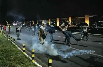  ?? Eduardo Anizelli/Folhapress ?? Manifestan­tes entram em conflito com a polícia em ato em frente ao Palácio do Planalto