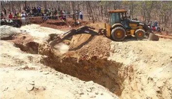  ?? Picture by Shel- ?? An excavator moves soil to enable access to a quarry where the bodies of illegal gold miners remain trapped under a boulder after the quarry collapsed in at Chatyoka mine shaft in Concession yesterday.