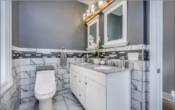  ?? Greg Sproul ?? The master bathroom has porcelain tile that looks like marble.