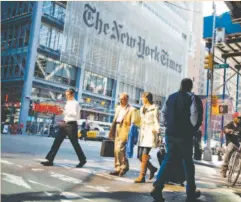  ??  ?? PEDESTRIAN­S PASS in front of The New York Times Co. headquarte­rs in New York.