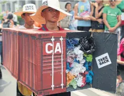  ?? AARON FAVILA THE ASSOCIATED PRESS FILE PHOTO ?? Filipino environmen­tal activists wear a mock shipping container filled with garbage in May 2015 to symbolize the 103 containers shipped from Canada.