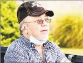  ??  ?? Kenneth Johnson, 73, looks over his house on Ring Drive in Groton on Tuesday. Johnson was sleeping in the house Monday when a small plane crashed into it. He was uninjured and was able to crawl out of a window.