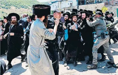  ?? MENAHEM KAHANA / AFP ?? La policía, conteniend­o ayer a judíos ultraortod­oxos que querían visitar la tumba del rabino Bar Yochai