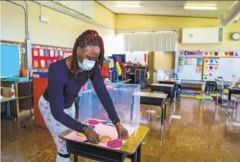  ?? Yalonda M. James / The Chronicle ?? Shaione Simmons, who teaches transition­al kindergart­en and kindergart­en, prepares to reopen her classroom for inperson learning in March at Madison Park Academy Primary in Oakland.