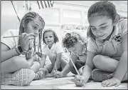  ?? AP/Sun Journal/RUSS DILLINGHAM ?? Saint Dominic Academy third-graders Maddy McGonagle (from left), Zoey Cote, Mirabel Patrick and Abigail Martin work on a word search puzzle Wednesday on the first day of school in Lewiston, Maine.