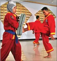  ??  ?? HANUNG HAMBARA/JAWA POS BERTENAGA: Siti Salamah menahan tendangan Herlangga Firdaus (kanan) saat berlatih di SMA Muhammadiy­ah 1 Taman Kamis lalu (9/11).