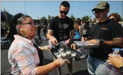  ?? Arkansas Democrat-Gazette/THOMAS METTHE ?? Ivonne Galvan (left) hands out cheese dip during Saturday’s competitio­n in Little Rock. More photos are available at arkansason­line. com/106cheese/