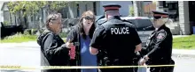 ?? COLIN PERKEL/THE CANADIAN PRESS ?? Neighbours Cathy Larocque, left, and Marjo Daniels talk to police about a home invasion in Hamilton, Ont., on Tuesday. One man was shot and gravely wounded, while others sustained lesser injuries, police said.