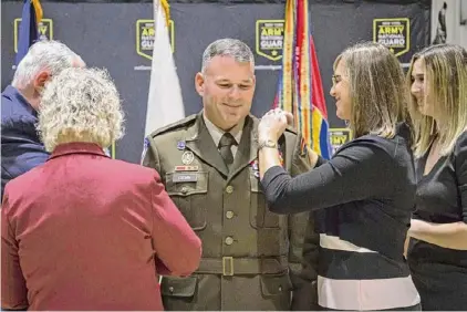  ?? Courtesy of New York Army National Guard ?? Family members pin new brigadier general rank insignias on Christophe­r Cronin during his promotion ceremony at the Army Aviation Flight Facility in Rochester.