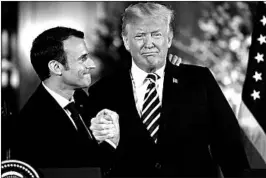  ?? SHAWN THEW/EPA ?? French leader Emmanuel Macron clasps hands with President Donald Trump on Tuesday.