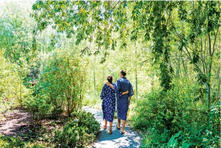  ?? Jason Henry / Special To The Chronicle ?? Rene (left) and Jason Robinson stroll at Osmosis Day Spa Sanctuary in Freestone, where Fork Roadhouse provides food.