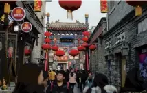  ??  ?? From top, a rickshaw tour; a paramilita­ry guard; people walk under lanterns displayed for the Lunar New Year