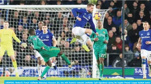  ?? — AFP ?? LIVERPOOL: Watford’s French midfielder Abdoulaye Doucoure (2L) vies with Everton’s Icelandic midfielder Gylfi Sigurdsson during the English Premier League football match between Everton and Watford at Goodison Park in Liverpool, north west England on Monday.