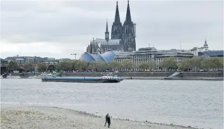  ??  ?? A ship on the Rhine River passes the cathedral in Cologne, Germany, during historical­ly low water levels.