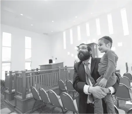  ?? PHOTOS BY DARREN STONE, TIMES COLONIST ?? Rabbi Meir Kaplan and his three-year-old son, Sholom Ber Kaplan, check out the new Chabad Centre for Jewish Life and Learning on Glasgow Street, near Topaz Park, in Victoria on Wednesday.