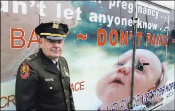  ?? FRANK ELTMAN/THE ASSOCIATED PRESS ?? Tim Jaccard stands Dec. 12 in front of a trailer in Wantagh, N.Y., that advertises a hotline where mothers can call to arrange to safely relinquish babies they are unwilling or unable to care for, to a responsibl­e party. The retired ambulance medic...