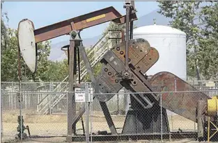  ?? CALIFORNIA­N FILE PHOTO ?? In this file photo, an oil pumping unit and storage tank near Shane Court in Arvin is surrounded by residentia­l apartments, single-family homes and commercial businesses.