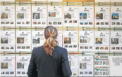  ??  ?? Una mujer mira varios carteles de vivienda que se alquilan.