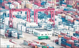  ??  ?? In this file photo, a cargo truck drives amid stacked shipping containers at the Yangshan port in Shanghai. China’s export orders shrank in September as a tariff battle with Washington over technology escalated, adding to downward pressure on the world’s No. 2 economy, two surveys showed, Sept 30, 2018. The reports add to signs Chinese trade, which had held up despite US President Donald Trump’s tariff hikes, might be weakening. That adds to pressure on an economy that already was forecast to cool due to slowing global consumer demand and lendingcon­trols imposed to rein in a debt boom. (AP)