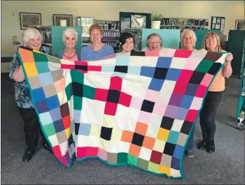  ??  ?? Members of Friendly Yarns with Sarah Thompson, centre, holding the special quilt.