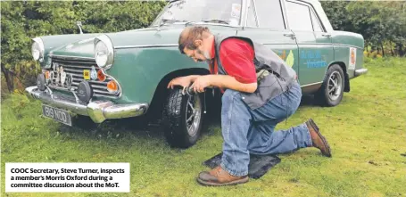  ??  ?? COOC Secretary, Steve Turner, inspects a member’s Morris Oxford during a committee discussion about the MoT.