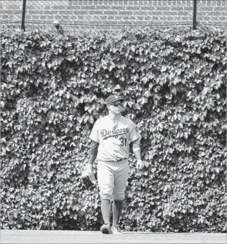  ?? Charles Rex Arbogast Associated Press ?? THE DODGERS’ Joc Pederson walks away from Anthony Rizzo’s home run stuck in the “basket” fence in center field during the eighth inning at Chicago. The Cubs hit four home runs.