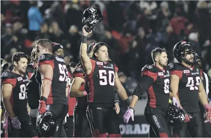  ?? JUSTIN TANG/THE CANADIAN PRESS ?? Redblacks long snapper Louis-Philippe Bourassa, centre, holds up his helmet as the team celebrates their win against the Tiger-Cats in Ottawa on Friday. The Redblacks finish the regular season at 8-9-1 as they continue their defence of their Grey Cup...