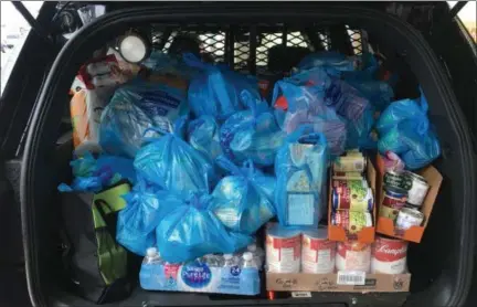  ?? ANDREW CASS — THE NEWS-HERALD ?? Mentor police Nov. 18 filled police SUVs with donated food for area pantries and collected cash donations for a Kops-N-Kids program.